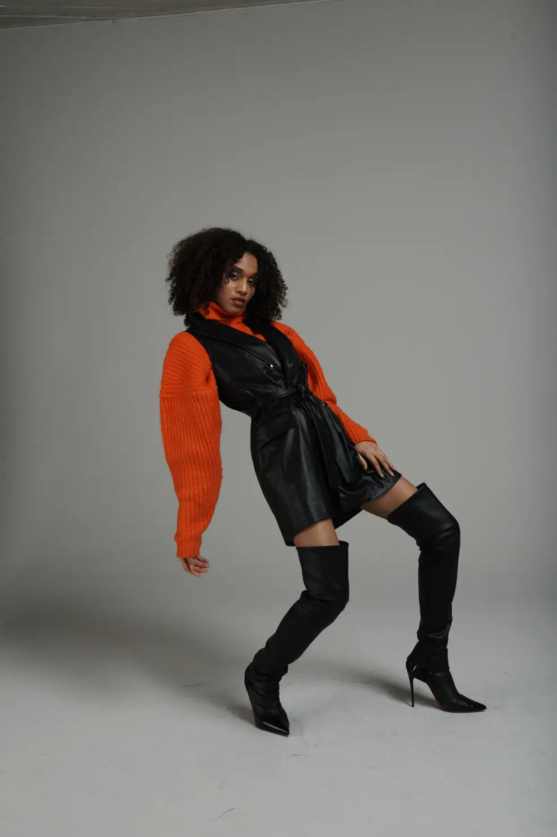 Femme portant PIMP UP™ BASIC BLACK avec des escarpins noirs et un pull orange